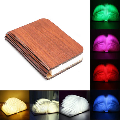 Folding book lamp open in a full circle, glowing warm on a shelf