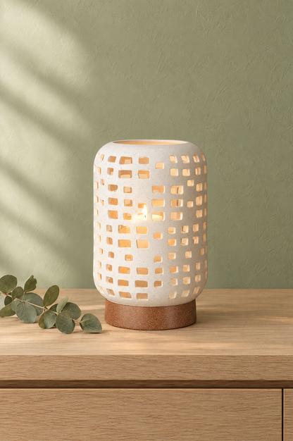 White ceramic lantern candle holder glowing on an oak console against a sage green wall